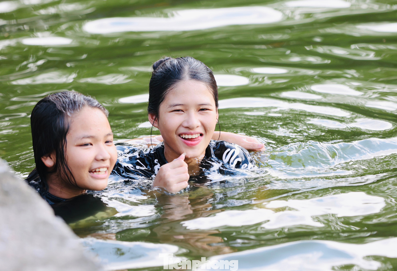 Nụ cười rạng rỡ của hai chị em khi được thoả thích vẫy vùng trong làn nước mát của hồ.