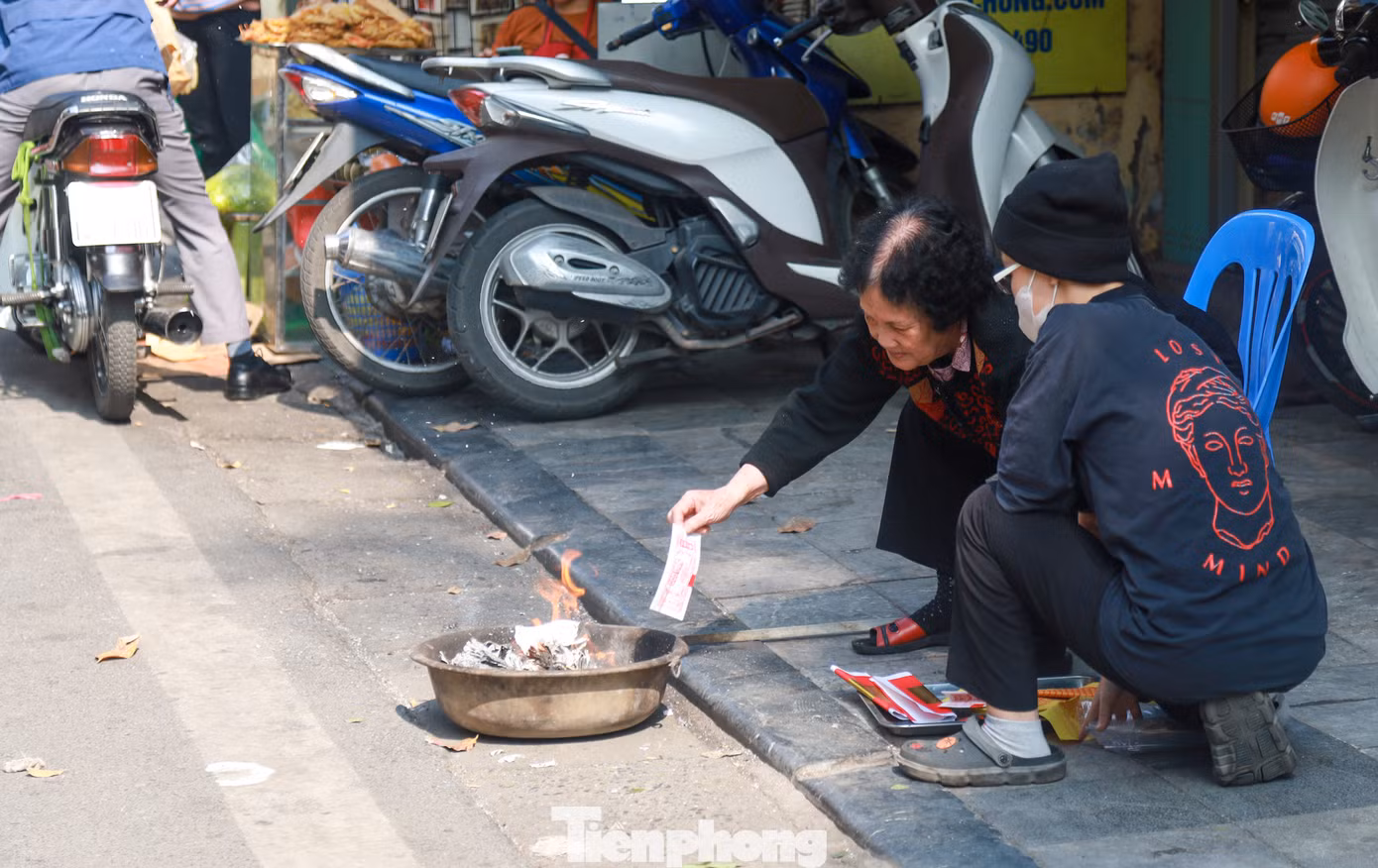 Nhiều người cao tuổi tranh thủ hàn huyên câu chuyện trong lúc hoá vàng tiễn ông Công ông Táo.