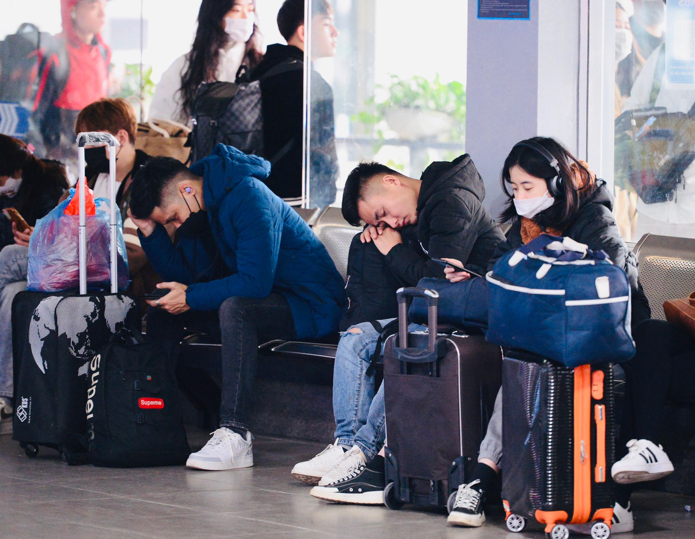 Nhiều hành khách mệt mỏi, ngủ gục trong lúc đợi xe tới giờ xuất bến.