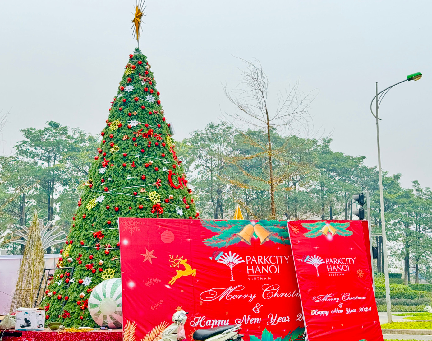 Gần 1 tháng nữa là đến dịp Giáng sinh 2023, nhiều tòa nhà và trung tâm thương mại ở Hà Nội đã bắt đầu trang trí, dựng cây thông Noel chào đón khách tới mua sắm. Trước khu chung cư tại Hà Đông, một cây thông khổng lồ được trang trí bắt mắt đang được gấp rút hoàn thiện.