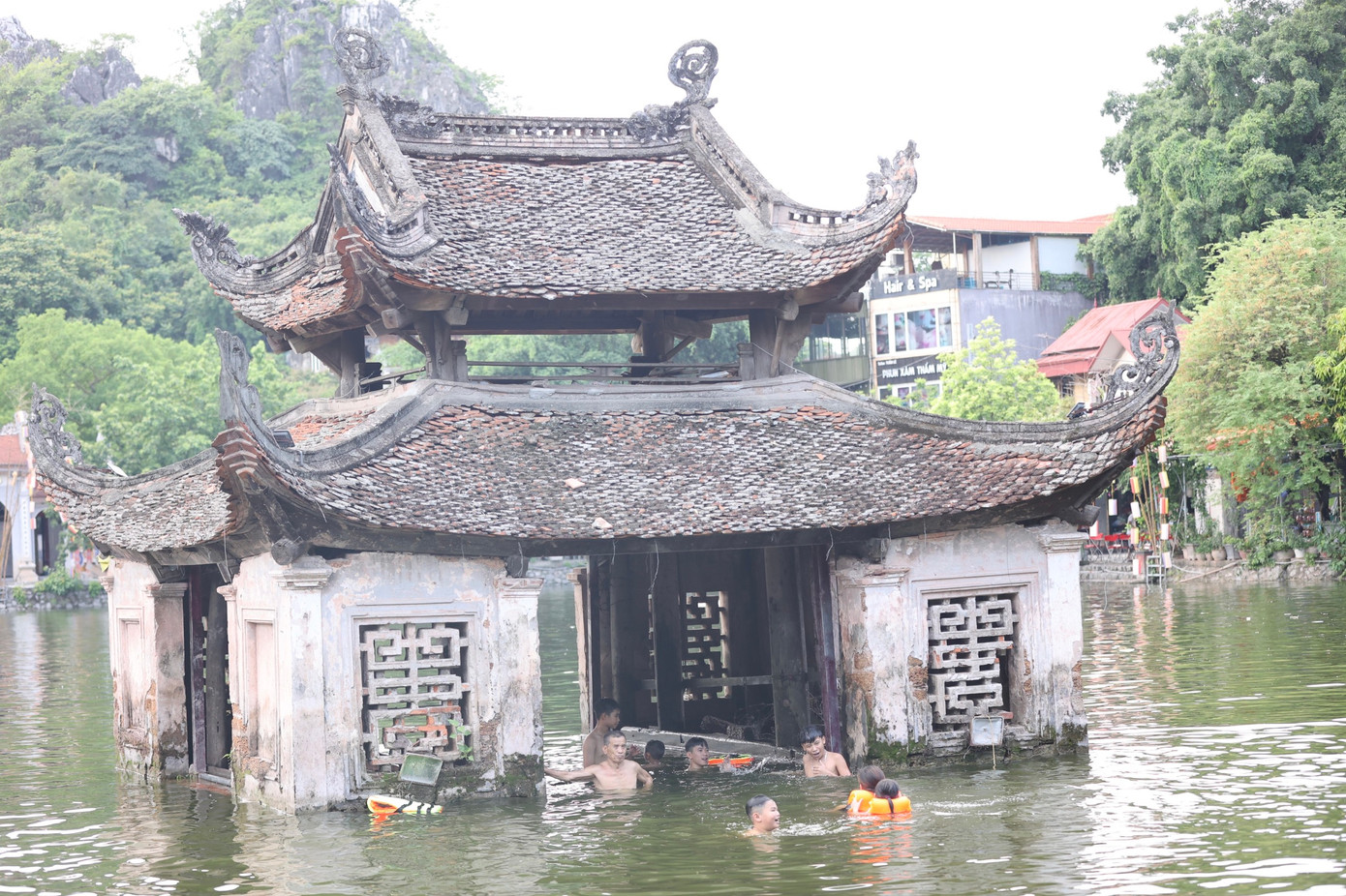 Trẻ em tới tắm giải nhiệt tại hồ Long Trì thích bơi ra khu Thủy Đình, vốn là nơi dùng để biểu diễn múa rối nước trong các chương trình lễ hội.