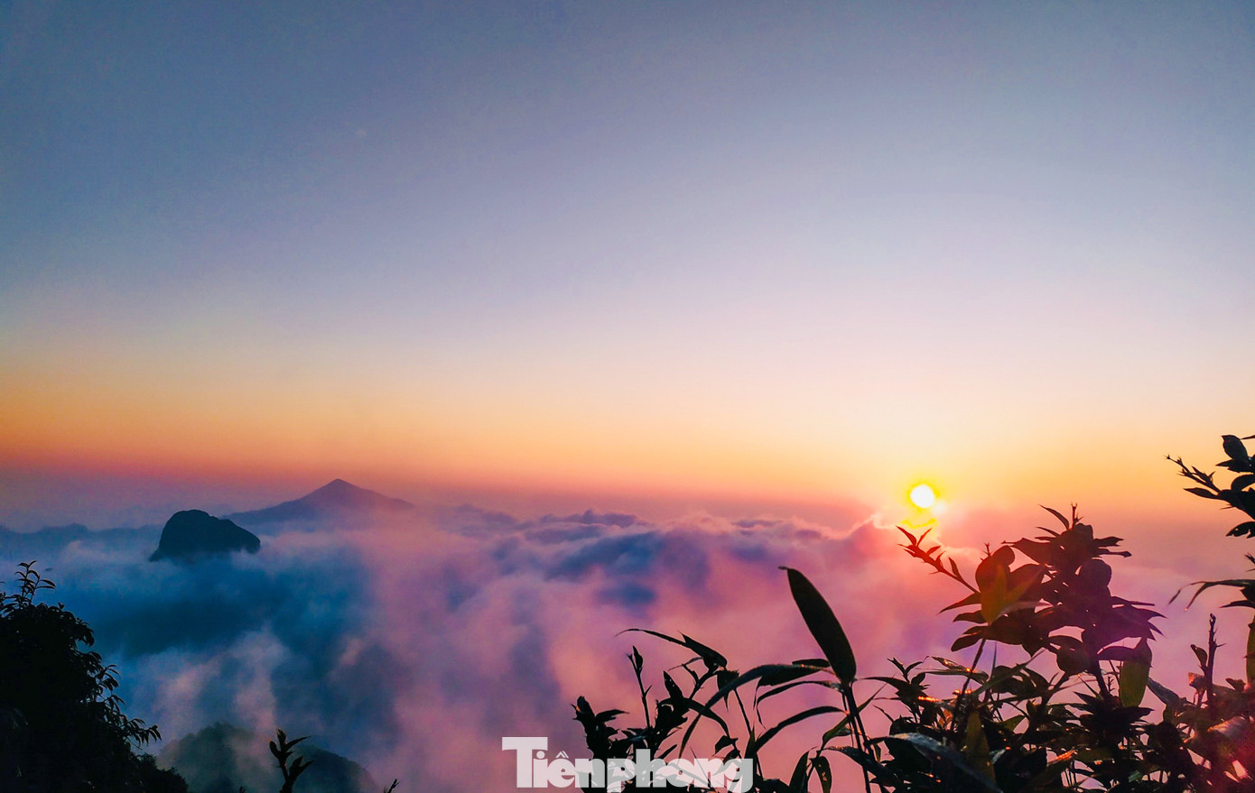 Từng tầng mây khép kín, xếp chồng dày đặc lên nhau phủ kín cả ngọn núi. Từng tia nắng dần xuyên qua các lớp mây dày đặc ấy chiếu rọi xuống từng chiếc lá còn đẫm sương mai tạo nên khung cảnh kỳ vỹ, kỳ ảo.