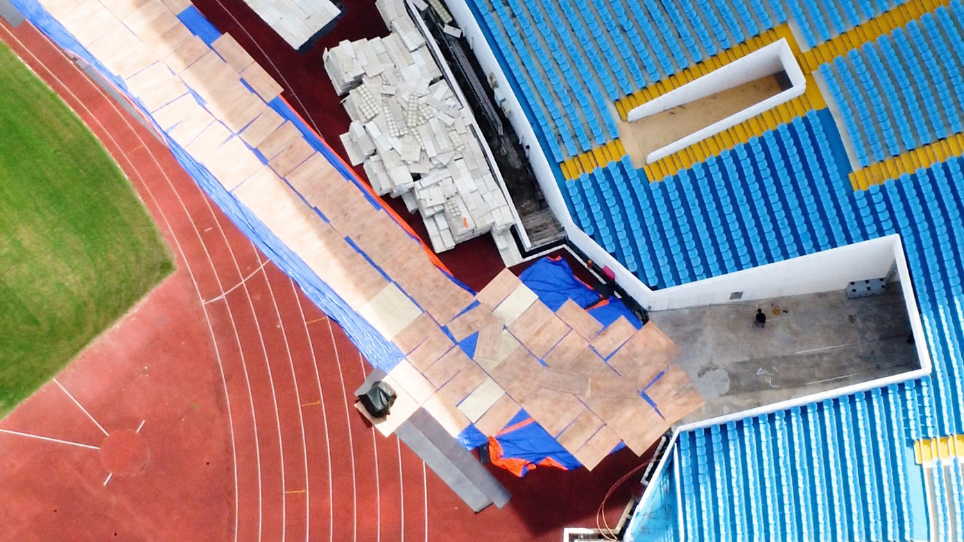 Phía bên trong sân vận động các lớp thảm đang được trải ra để bảo vệ mặt sân cỏ...