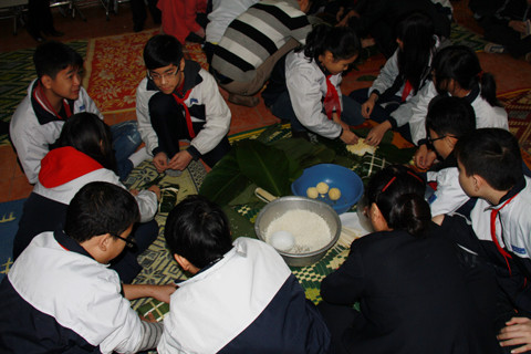 Các bạn học sinh Việt Nam cũng thử sức gói bánh chưng. Ảnh: Trường Phong