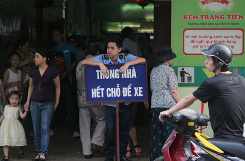 Nhân viên bảo vệ cửa hàng kem Tràng Tiền dựng biển thông báo hết chỗ để xe