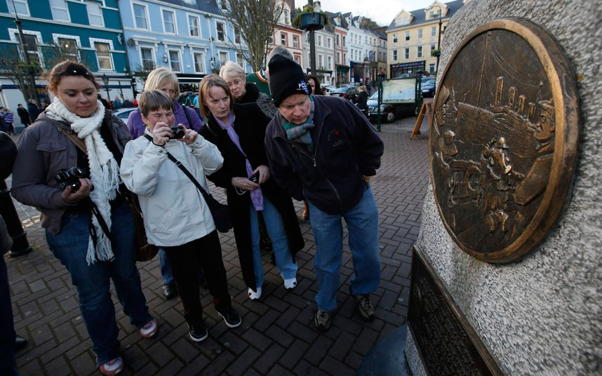 Hành khách đã có mặt ở bến cảng Cobh, Ireland vào hôm nay 10-4. Trong ảnh các hành khách đang đứng trước đài tưởng niệm được xây dựng tại đây. 