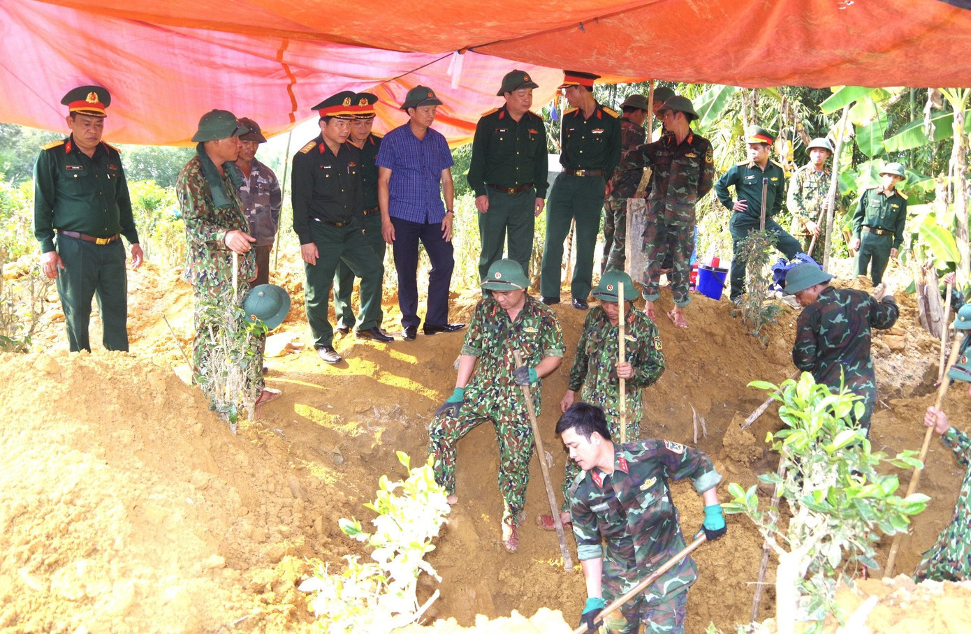 Đội 584 tiến hành tìm kiếm, quy tập hài cốt liệt sĩ tại vườn nhà ông Trần Văn Trình. Ảnh: Xuân Diện