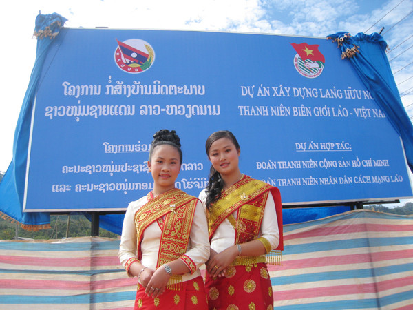 Hai thiếu nữ Lào bên tấm biển Dự án Làng Thanh niên Hữu nghị Biên giới Lào - Việt vừa được hai Bí thư thứ nhất cắm ở tỉnh Bolikhamxay