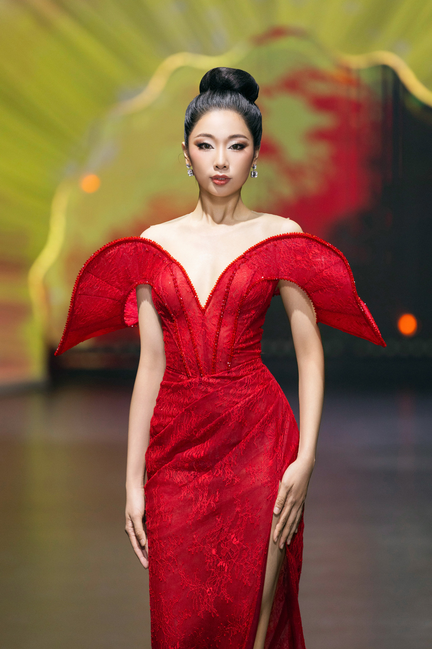 Tối 18/5, thí sinh Phạm Thùy Dương trình diễn trong show thời trang ở TPHCM. Cô diện bộ váy dạ hội tông màu đỏ với phần vai cách điệu cầu kỳ. Người đẹp búi tóc, trang điểm đậm với điểm nhấn là đôi mắt khói.