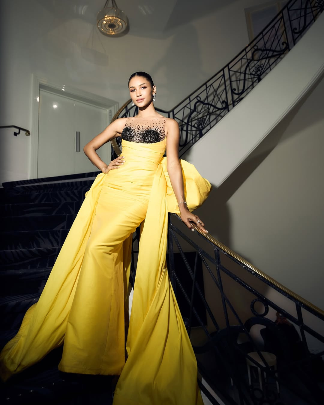 Người đẹp Praewwanich Ruangthong - Á hậu 1 Hoa hậu Siêu quốc gia 2022 - nổi bật trên thảm đỏ Liên hoan phim Cannes với thiết kế tông màu vàng rực rỡ, phần thân trên đính kết trên nền vải xuyên thấu. Điểm nhấn của trang phục là chiếc nơ có kích thước lớn ở phía sau.