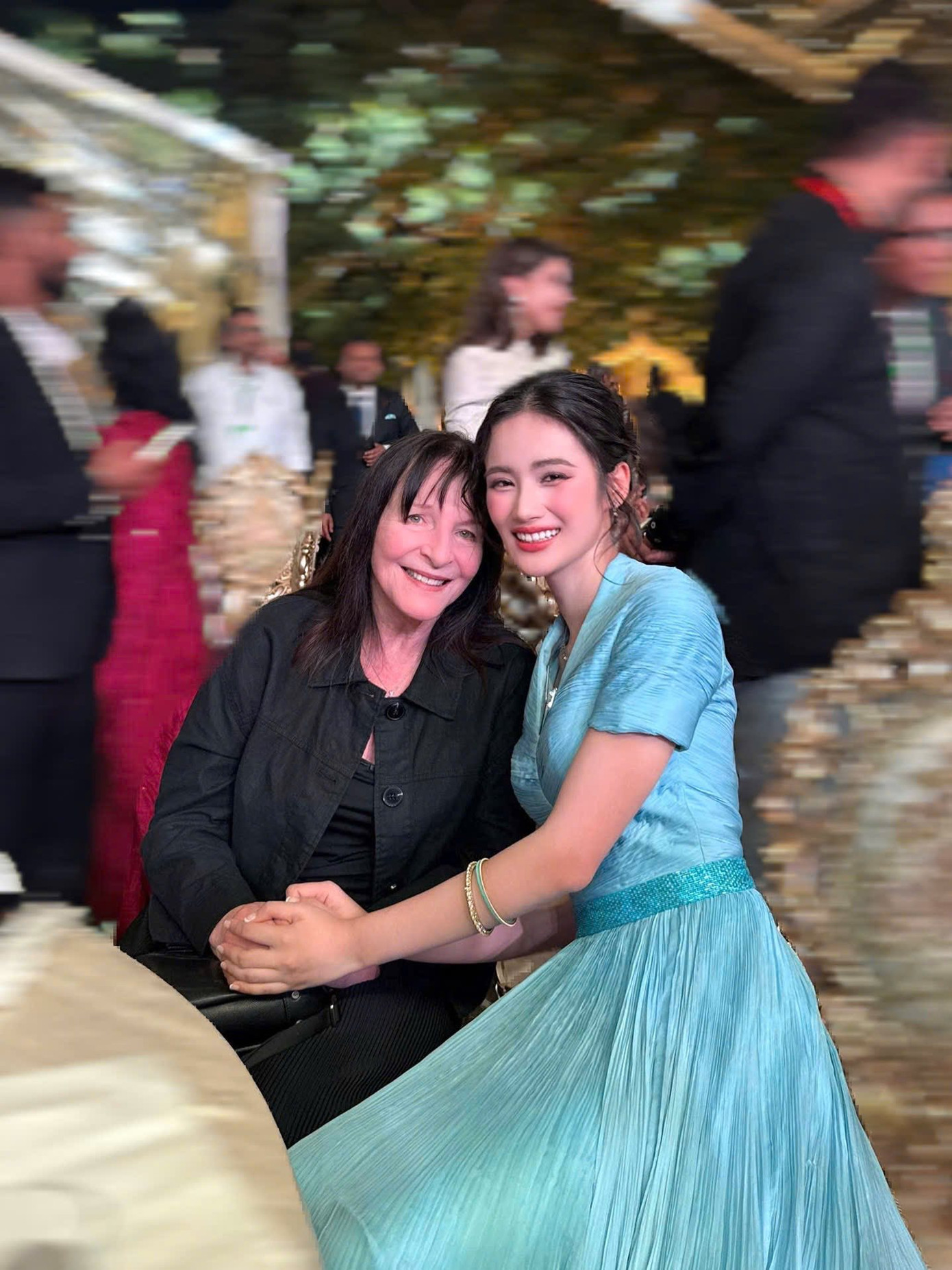 Ý Nhi chọn bộ váy tông màu xanh kín đáo khi cùng các thí sinh đi dạo trên đường phố Telangana, Ấn Độ. Cô cũng có dịp chụp ảnh cùng bà Julia Morley - Chủ tịch Hoa hậu Thế giới.