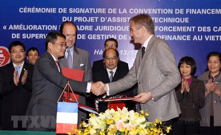 Đại diện Ngân hàng Nhà nước Việt Nam, Cơ quan Phát triển Pháp (AFD) và Đại sứ quán Pháp ký kết khoản viện trợ không hoàn lại trị giá 1 triệu Euro của Pháp giúp Việt Nam thực hiện dự án hỗ trợ kỹ thuật “Hoàn thiện khuôn khổ pháp lý và tăng cường năng lực quản lý, giám sát cho lĩnh vực tài chính vi mô tại Việt Nam (Hà Nội, 13/12/2011). (Ảnh: Trần Việt/TTXVN)