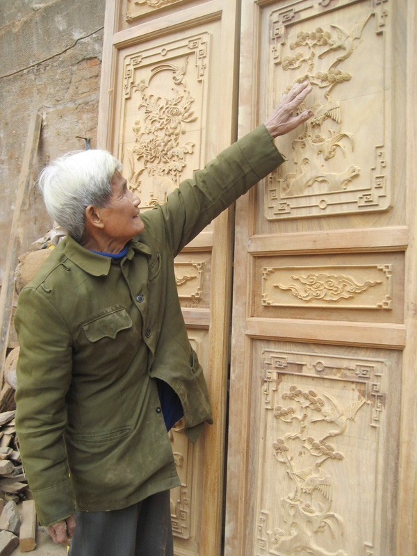 Ông Đỗ Đăng Tuyên mô tả những nét chạm khắc trên mặt cửa gỗ kiểu bức bàn. Ông Đỗ Đăng Tuyên mô tả những nét chạm khắc trên mặt cửa gỗ kiểu bức bàn