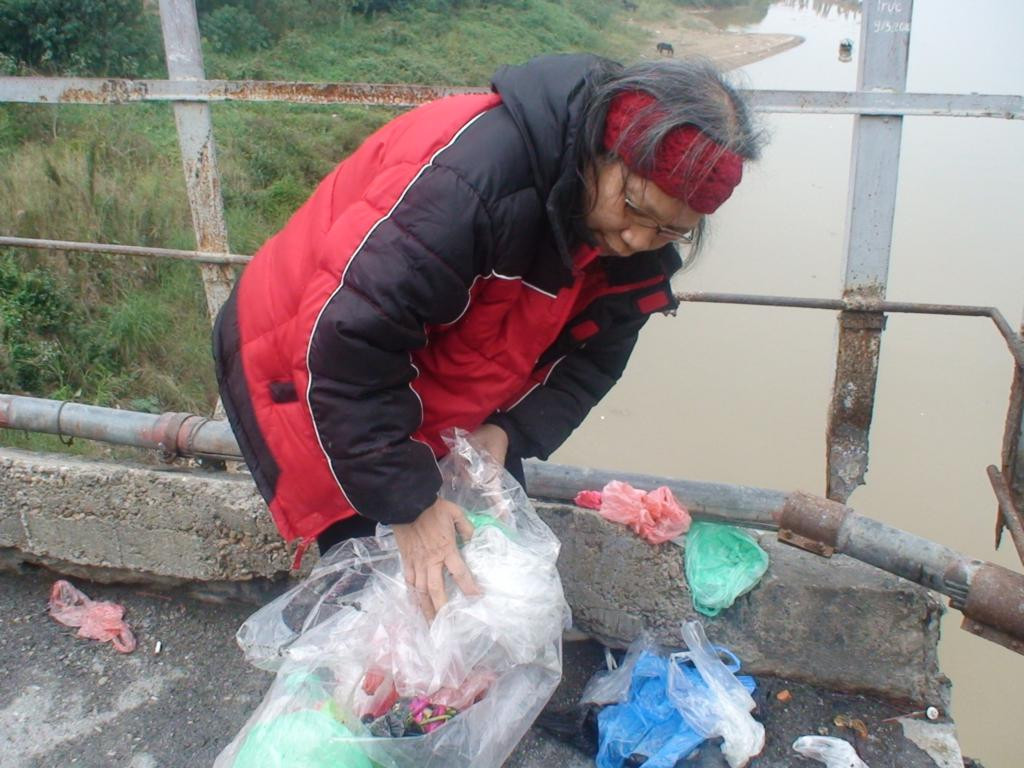 Tại cầu Long Biên, nhiều người mang những túi đầy vàng mã vừa hóa xong thả xuống sông Hồng