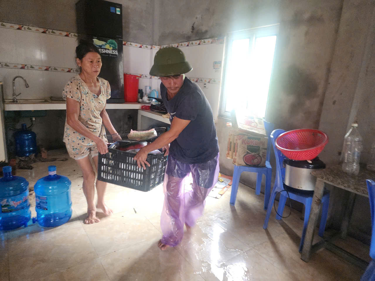 Nhiều gia đình khác trong xóm Vạn Tiên cũng đang di chuyển đồ đạc lên cao.