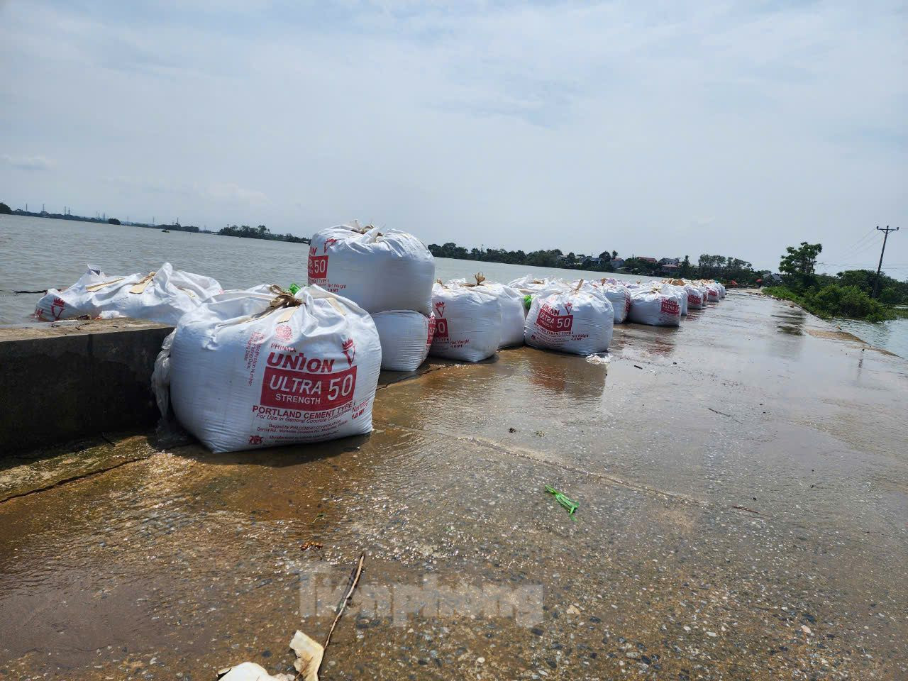 Nhiều tuyến đê trên địa bàn huyện bị tràn, khiến nước sông dâng cao. Trong ảnh là một đoạn tuyến đê thuộc xã Hòa Thạch bị tràn, đã được lực lượng chức năng gia cố.