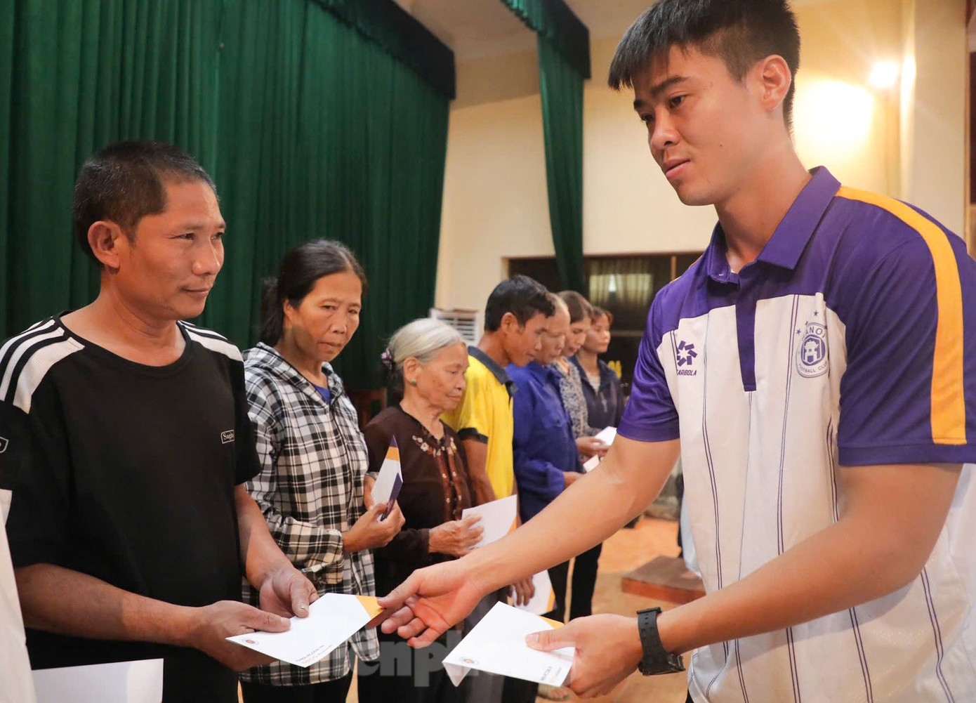 Cầu thủ Đỗ Duy Mạnh, CLB Bóng đá Hà Nội trao quà cho người dân khó khăn vùng lũ