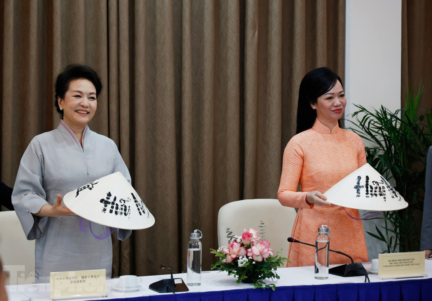 Hai Phu nhân trải nghiệm viết thư pháp trên nón lá. (Ảnh: Như Ý) Hai Phu nhân trải nghiệm viết thư pháp trên nón lá. (Ảnh: Như Ý)