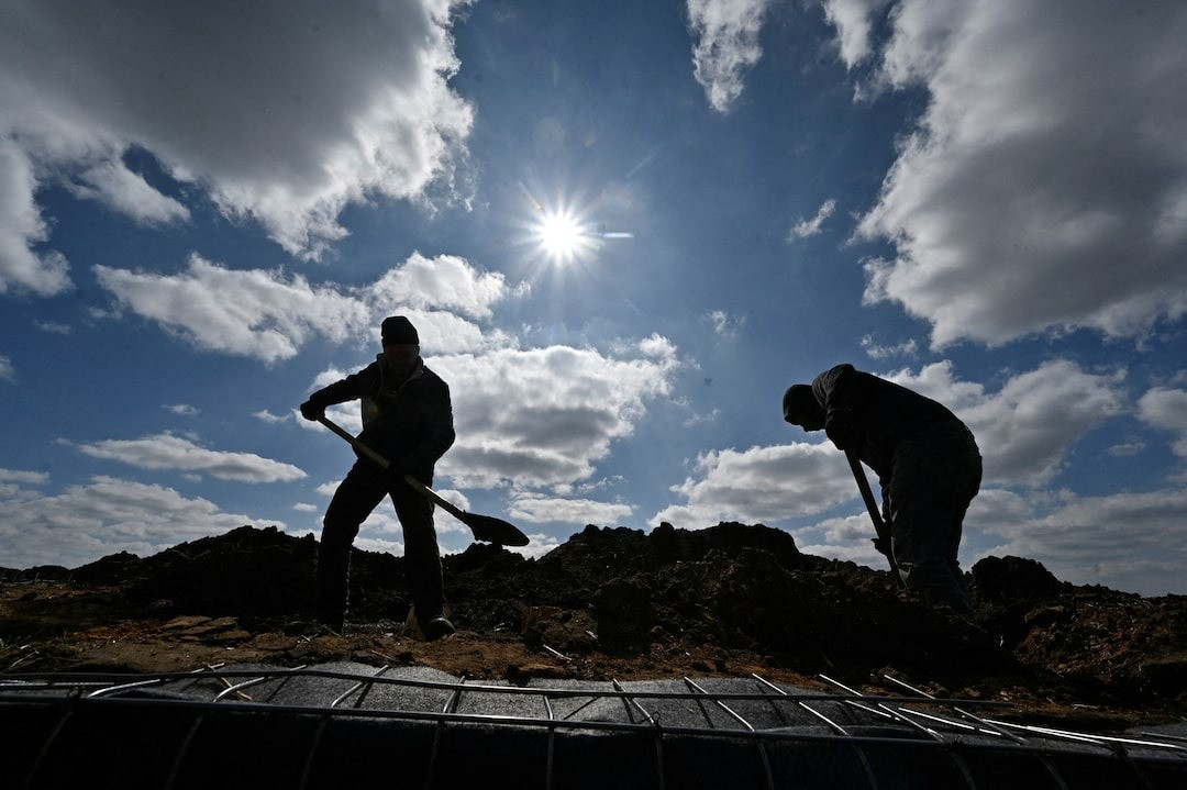 Các công nhân đào hào suốt ngày đêm. Ảnh: Reuters