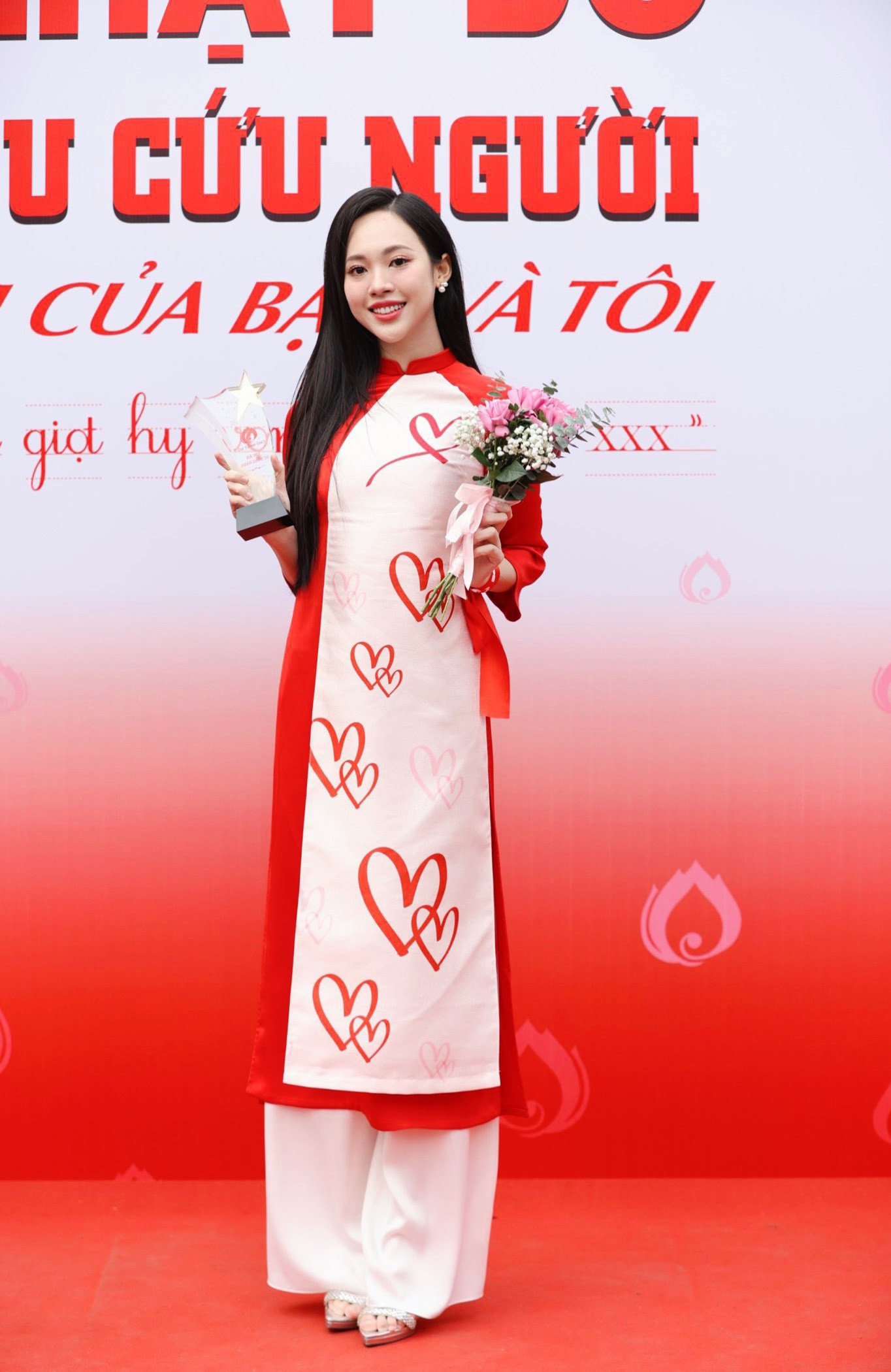 Á hậu Việt Nam 2022 Trịnh Thùy Linh cũng diện bộ áo dài đặc biệt do Hoa hậu Ngọc Hân thiết kế. Họa tiết trên áo dài là những trái tim, tượng trưng cho nghĩa cử hiến máu cao đẹp. Bên cạnh đó là hình ảnh những bàn tay cùng biểu tượng của các nhóm máu được đặt ở vị trí trái tim.