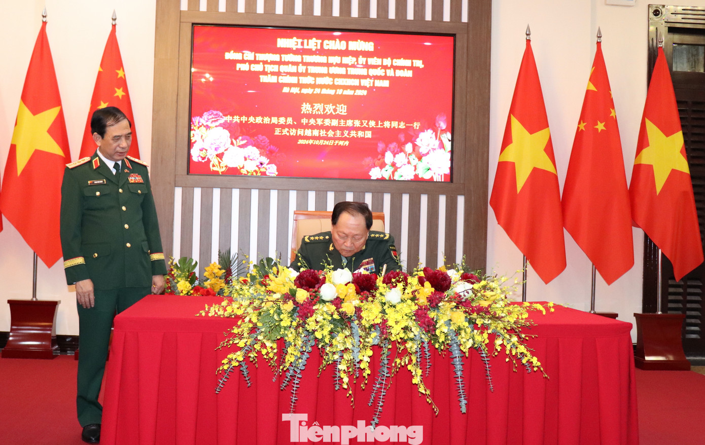 Thượng tướng Trương Hựu Hiệp ghi lưu bút sổ vàng trước khi bước vào buổi hội đàm.