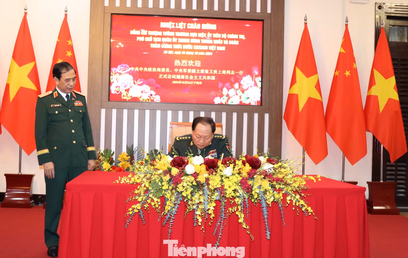 Thượng tướng Trương Hựu Hiệp ghi lưu bút sổ vàng trước khi bước vào buổi hội đàm.