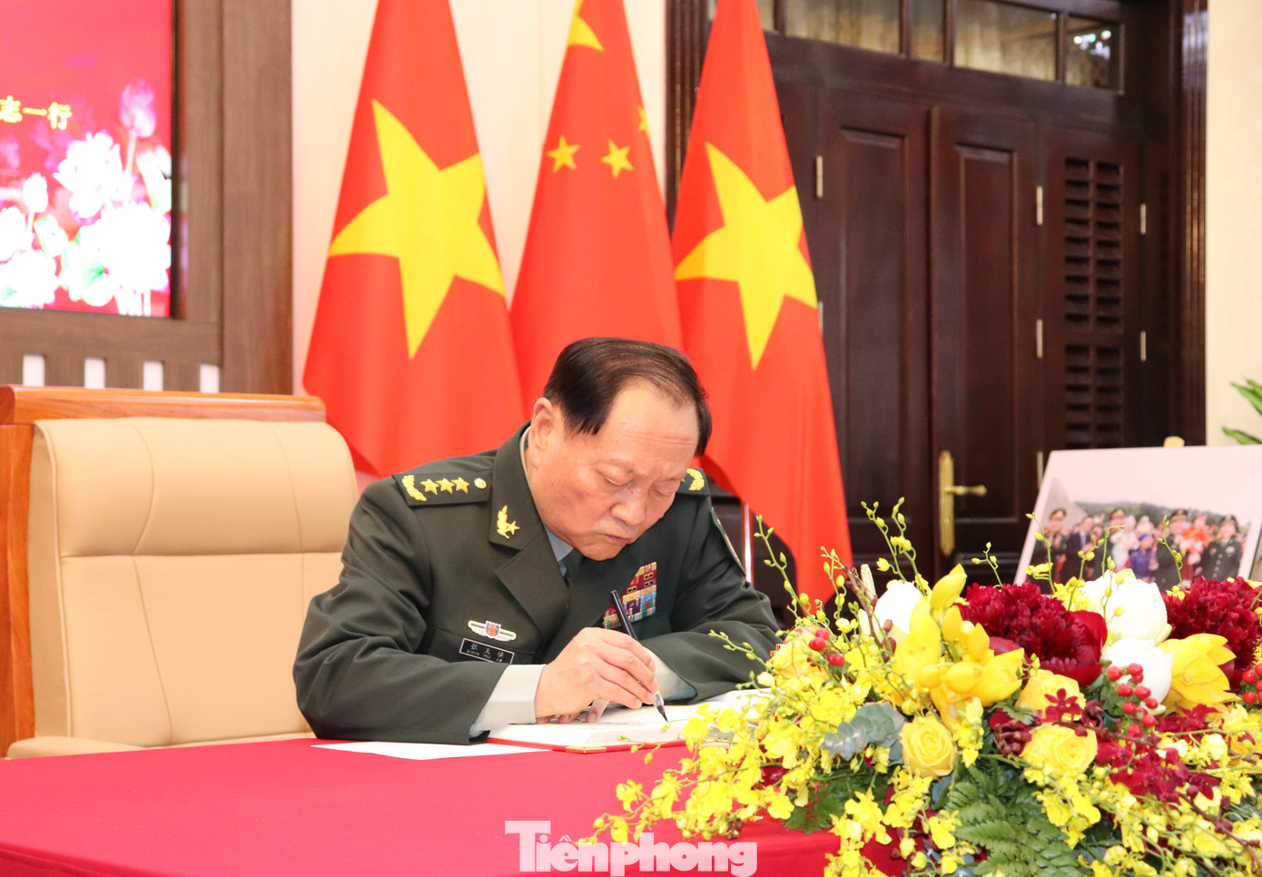 Thượng tướng Trương Hựu Hiệp ghi lưu bút sổ vàng trước khi bước vào buổi hội đàm.