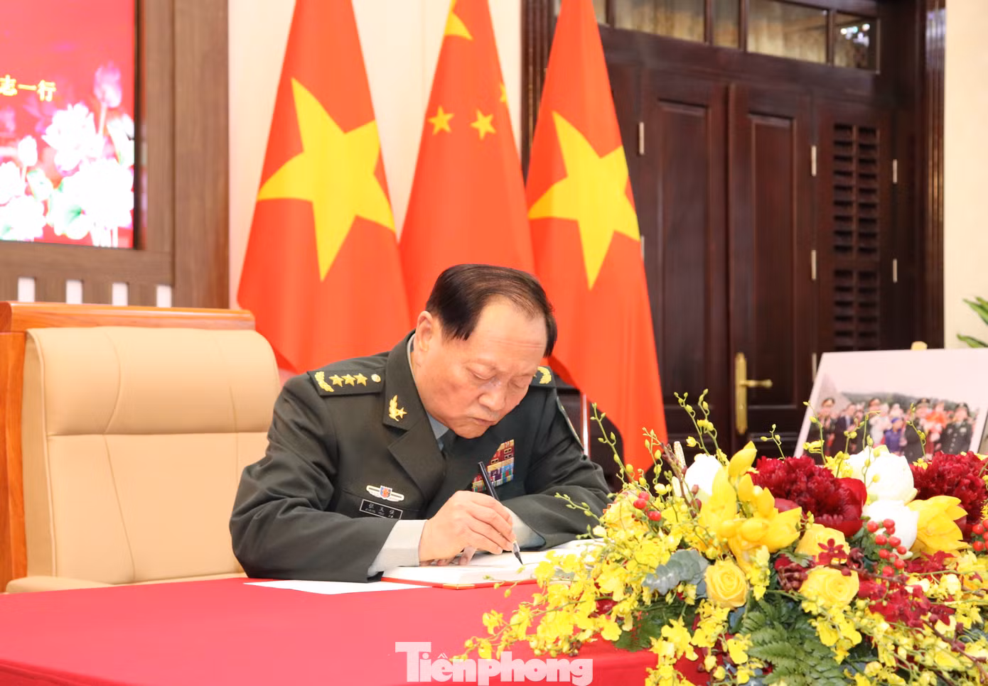 Thượng tướng Trương Hựu Hiệp ghi lưu bút sổ vàng trước khi bước vào buổi hội đàm.