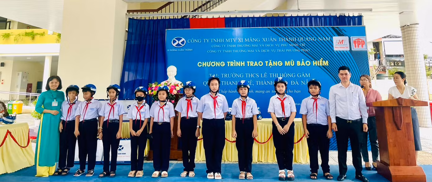Đại diện Xi Măng Xuân Thành trao tặng mũ bảo hiểm đạt chuẩn cho các em học sinh tại trường THCS Lê Thị Hồng Gấm (Thành phố Đà Nẵng)