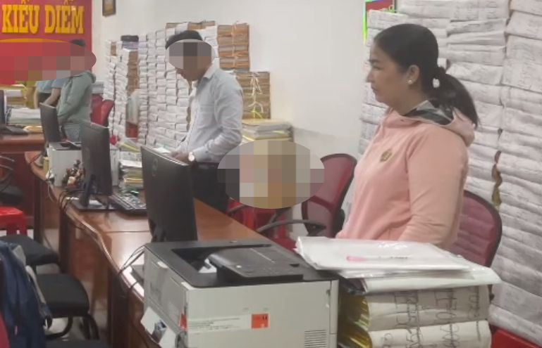 Diễm nghe đọc lệnh khám xét nơi làm việc. Ảnh công an cung cấp. Diễm nghe đọc lệnh khám xét nơi làm việc. Ảnh công an cung cấp.