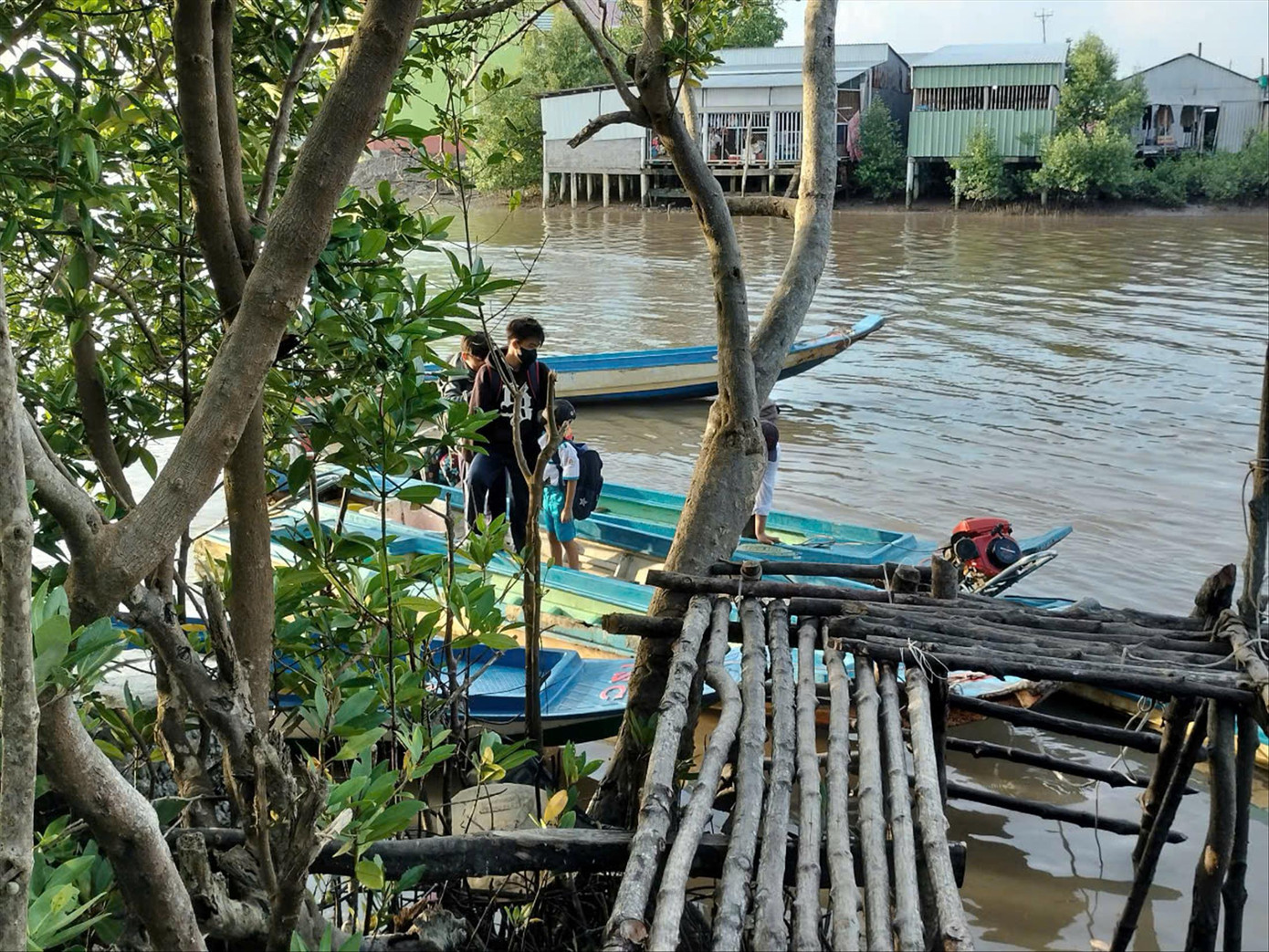 Phụ huynh đưa con đến trường bằng xuồng từ tờ mờ sáng.