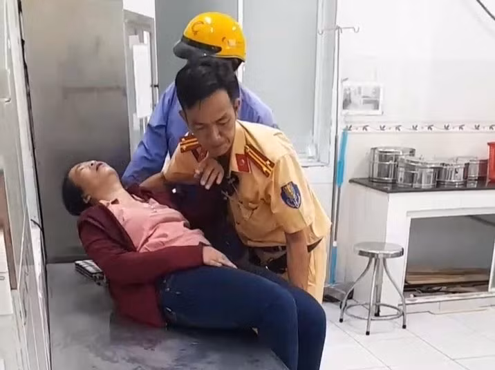 Trung tá Nguyễn Phương Anh hỗ trợ đưa người phụ nữ bị tai biến đến bệnh viện cấp cứu kịp thời. Ảnh: Hải Linh.
