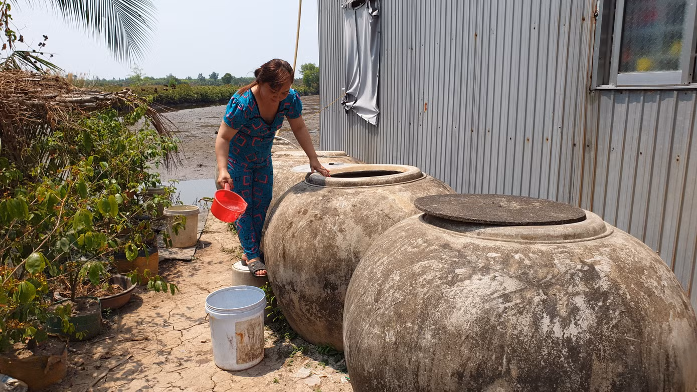 Nhiều gia đình chuẩn bị lu, khạp để chứa nước mua từ các ghe xài cầm cự qua ngày.