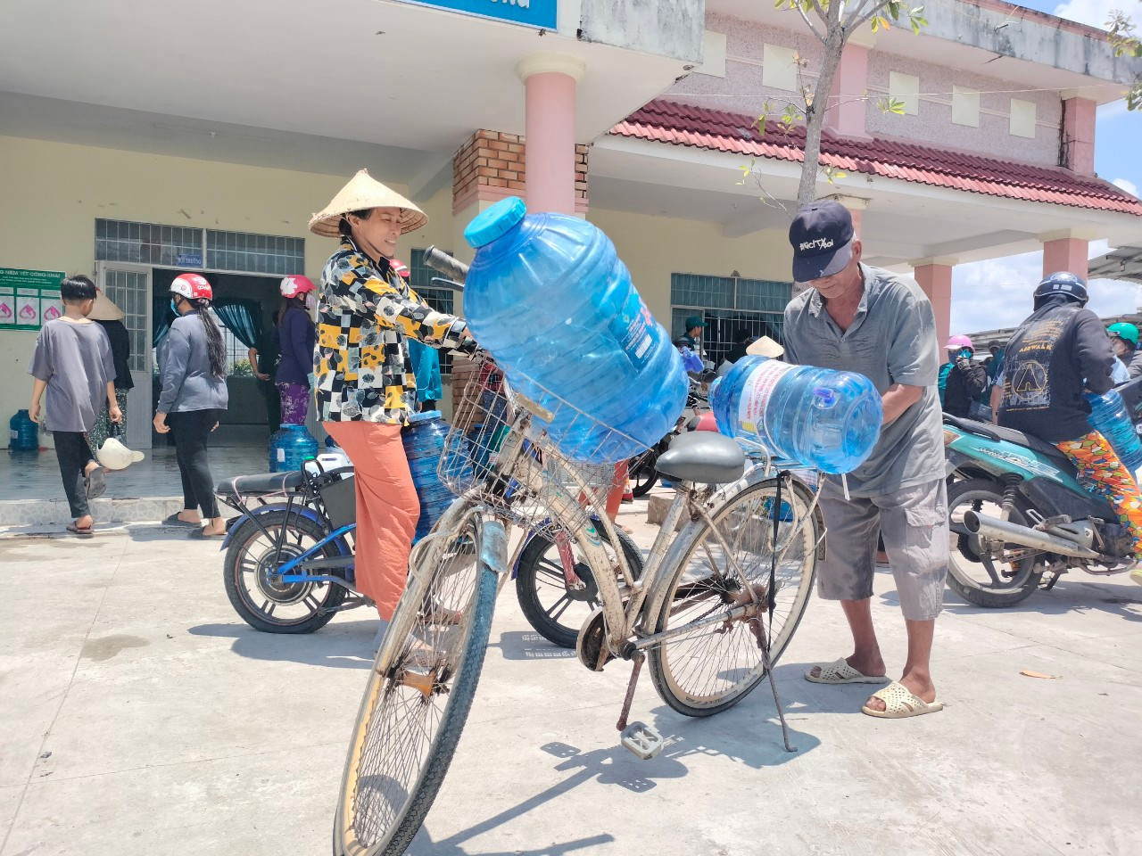 Chở nước lọc bằng xe đạp mang về nhà.