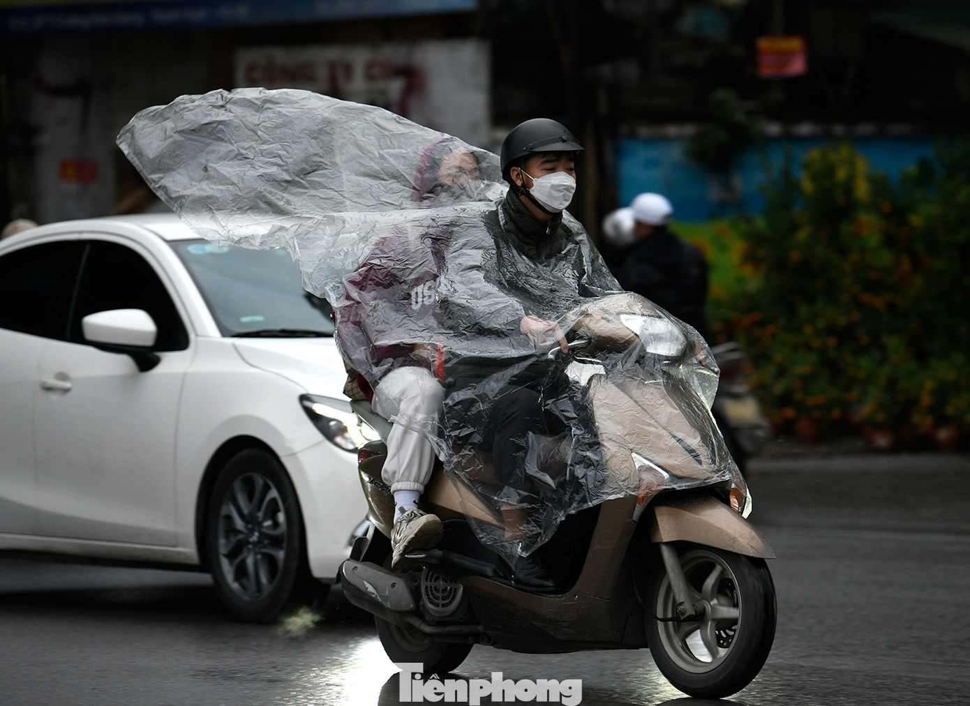 Cơn mưa phùn rải rác kèm không khí lạnh khiến người dân cảm nhận cái lạnh rõ hơn khi lưu thông trên đường.