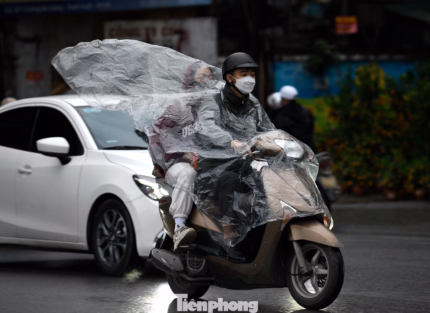 Cơn mưa phùn rải rác kèm không khí lạnh khiến người dân cảm nhận cái lạnh rõ hơn khi lưu thông trên đường.
