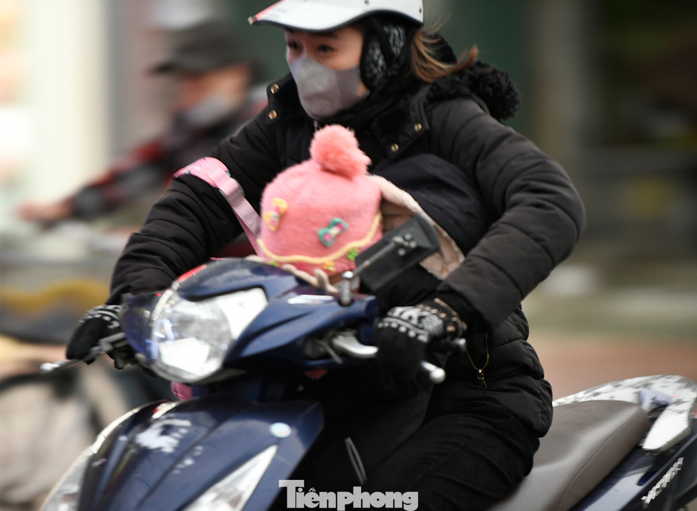 Một người mẹ vội vàng đưa con đến trường trong cái rét vào đầu giờ sáng nay.