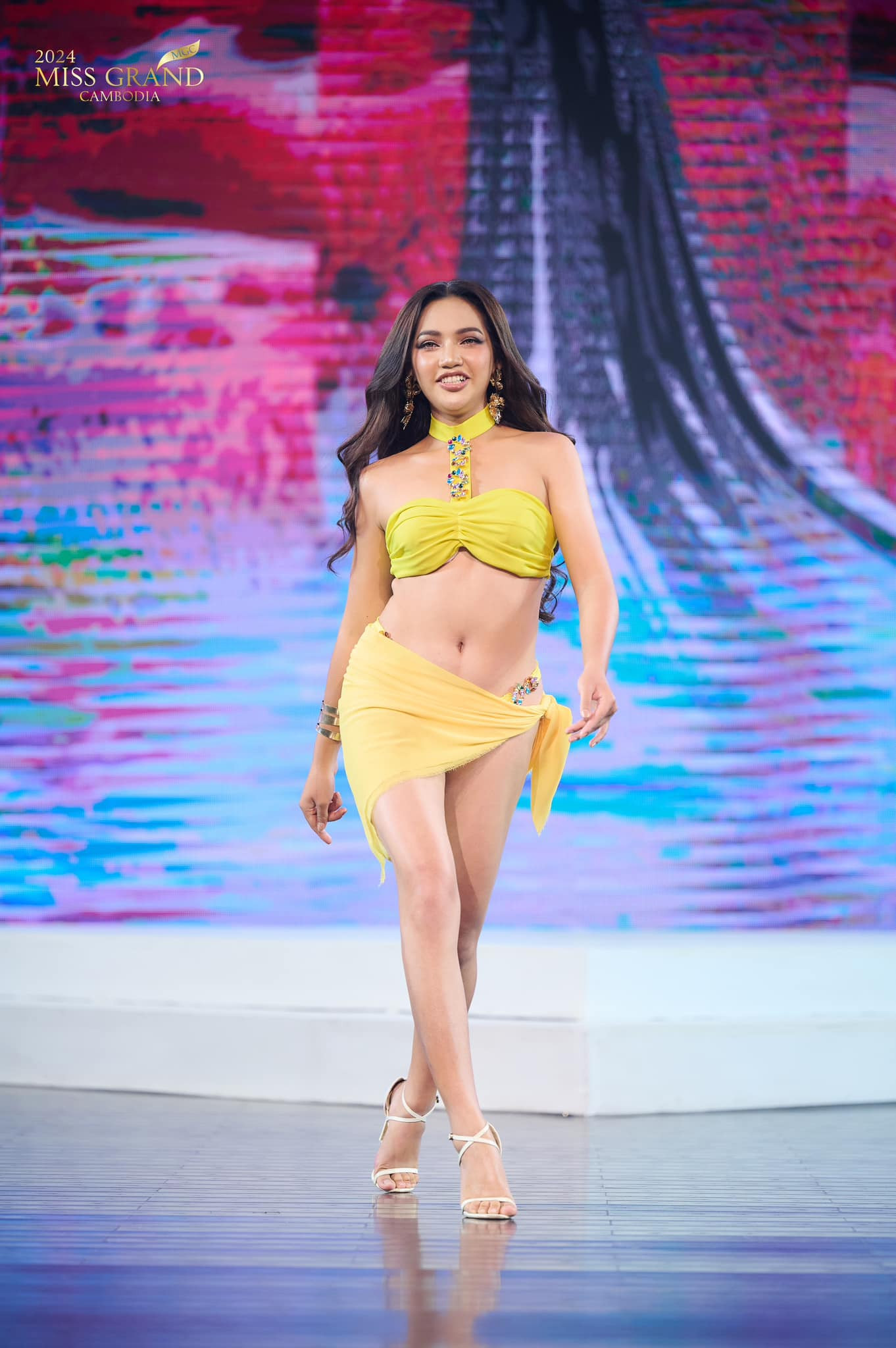 Trong phần thi áo tắm, thí sinh trình diễn thiết kế hai mảnh tông màu vàng nổi bật, kết hợp khăn choàng. Thiết kế có điểm nhấn là phần cổ được đính kết cầu kỳ.