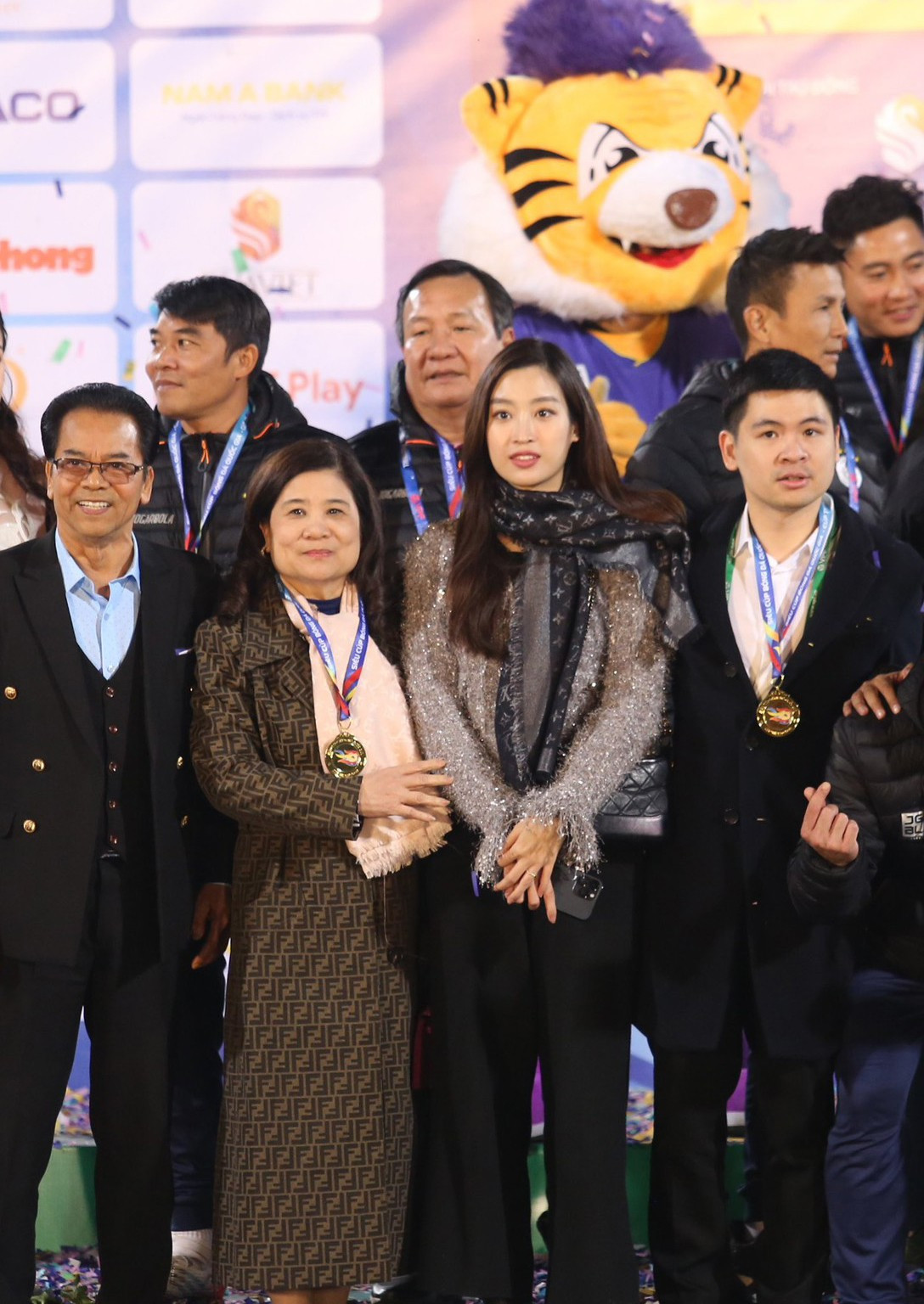 Hoa hậu Đỗ Mỹ Linh cùng ông xã và ban lãnh đạo CLB Hà Nội chụp ảnh lưu niệm cùng Siêu cúp bóng đá Quốc gia - Cúp THACO năm 2022 sau trận đấu.