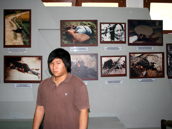 Trần Văn Viễn (con trai Trần Văn Đức) trước ảnh bà nội và ba mình tại nhà chứng tích Sơn Mỹ Ảnh: Trương Duy Nhất 