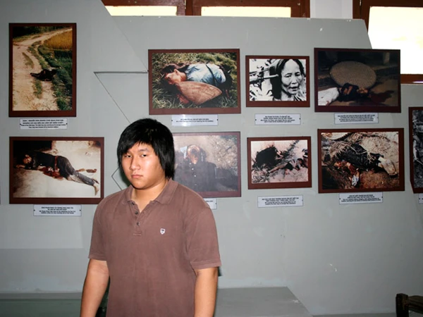 Trần Văn Viễn (con trai Trần Văn Đức) trước ảnh bà nội và ba mình tại nhà chứng tích Sơn Mỹ Ảnh: Trương Duy Nhất 