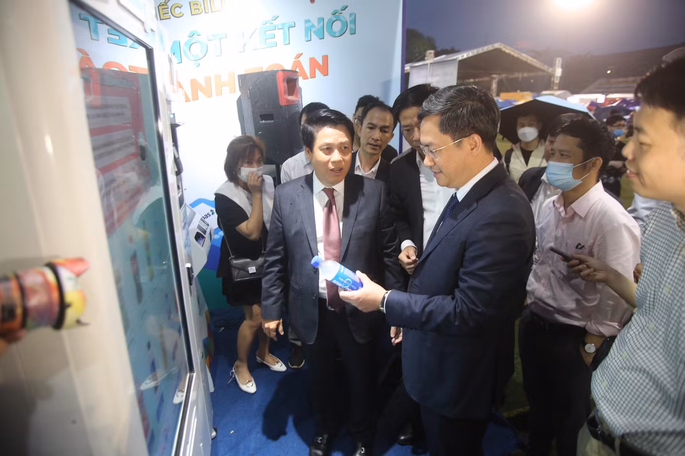 Phó Chủ tịch Hà Nội trải nghiệm thanh toán số bằng cách chạm vòng tay thanh toán trong vài giây tại quầy nước bán hàng tự động. Ông mua cho mình chai nước suối một cách dễ dàng chỉ bằng một chạm.