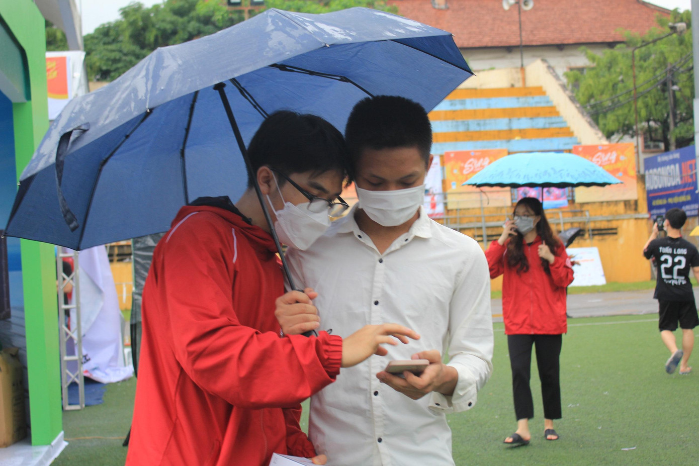 Các bạn sinh viên check in dưới mưa tham gia lễ hội mua sắm, trải nghiệm thanh toán không tiền mặt.