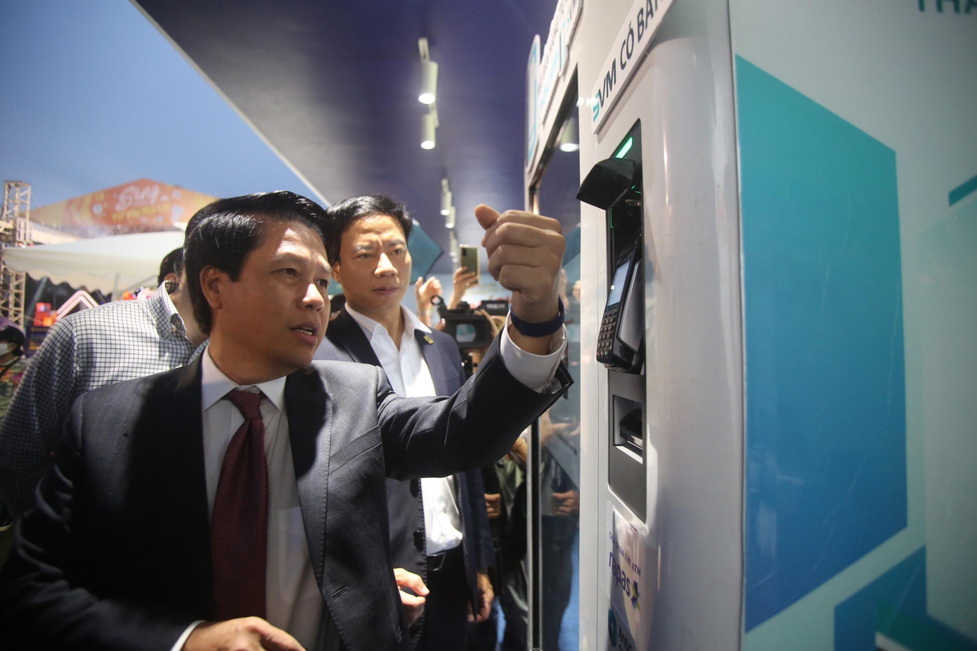 Phó Thống đốc NHNN Phạm Tiến Dũng trải nghiệm thanh toán bằng vòng tay của Napas tại quầy bán nước tự động. Chỉ chạm nhẹ 2 giây, lãnh đạo NHNN nhận ngay món đồ uống yêu thích.