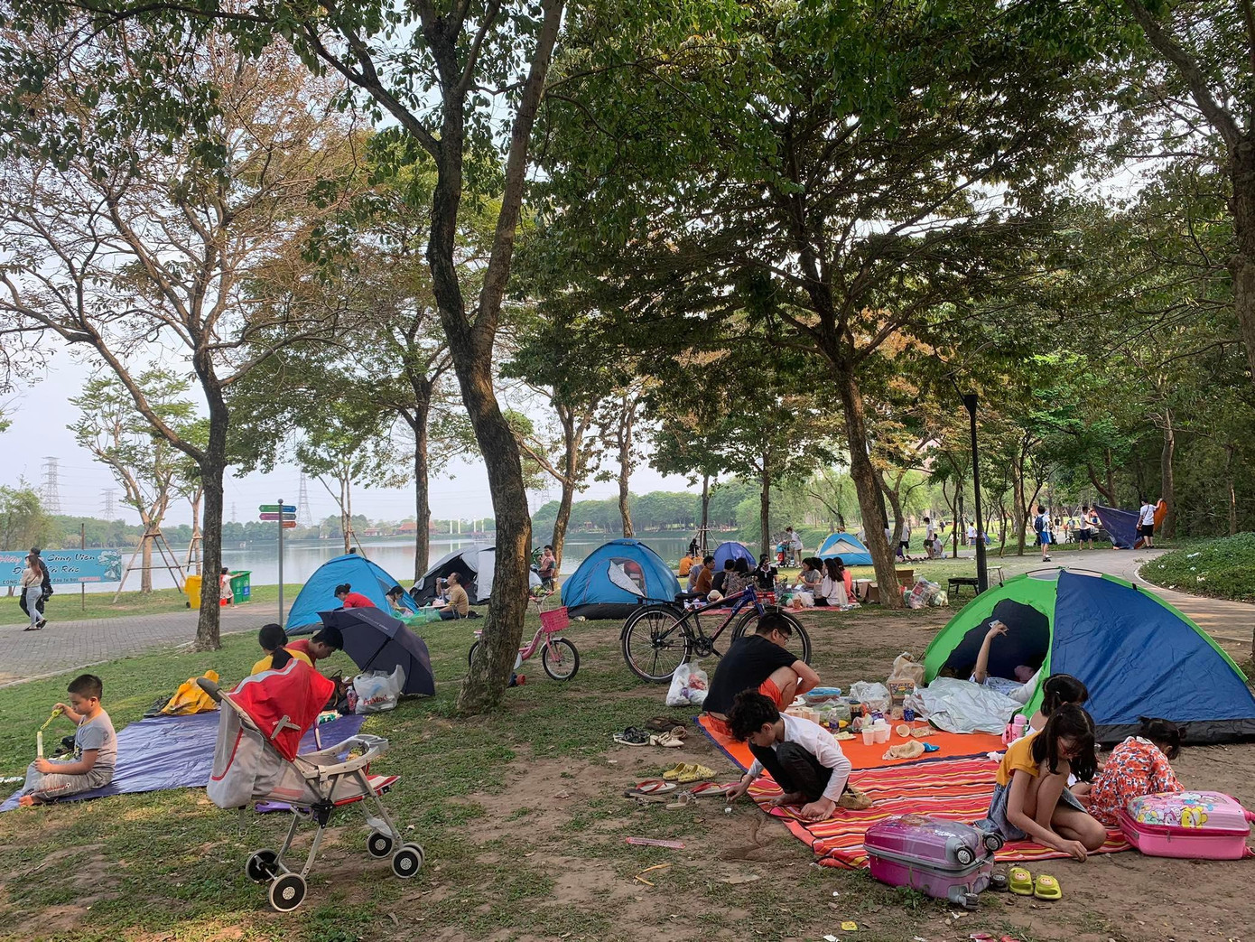 Ngay từ sáng 10/4, dòng người đông đúc đã đổ về công viên Yên Sở (Hoàng Mai, Hà Nội). Chị Thanh Hương (Hoàng Mai, Hà Nội) cho biết, gia đình chị chọn công viên ngoài trời để hưởng không khí trong lành và trẻ con có không gian chạy nhảy.... “Mình rời nhà từ 7 giờ sáng nhưng ra đến nơi đã rất đông người. Mọi người mang theo đồ cắm trại và ăn uống để thưởng thức. Cả người lớn và các bạn nhỏ đều rất vui", chị Hương nói. Ảnh: Ngọc Mai.