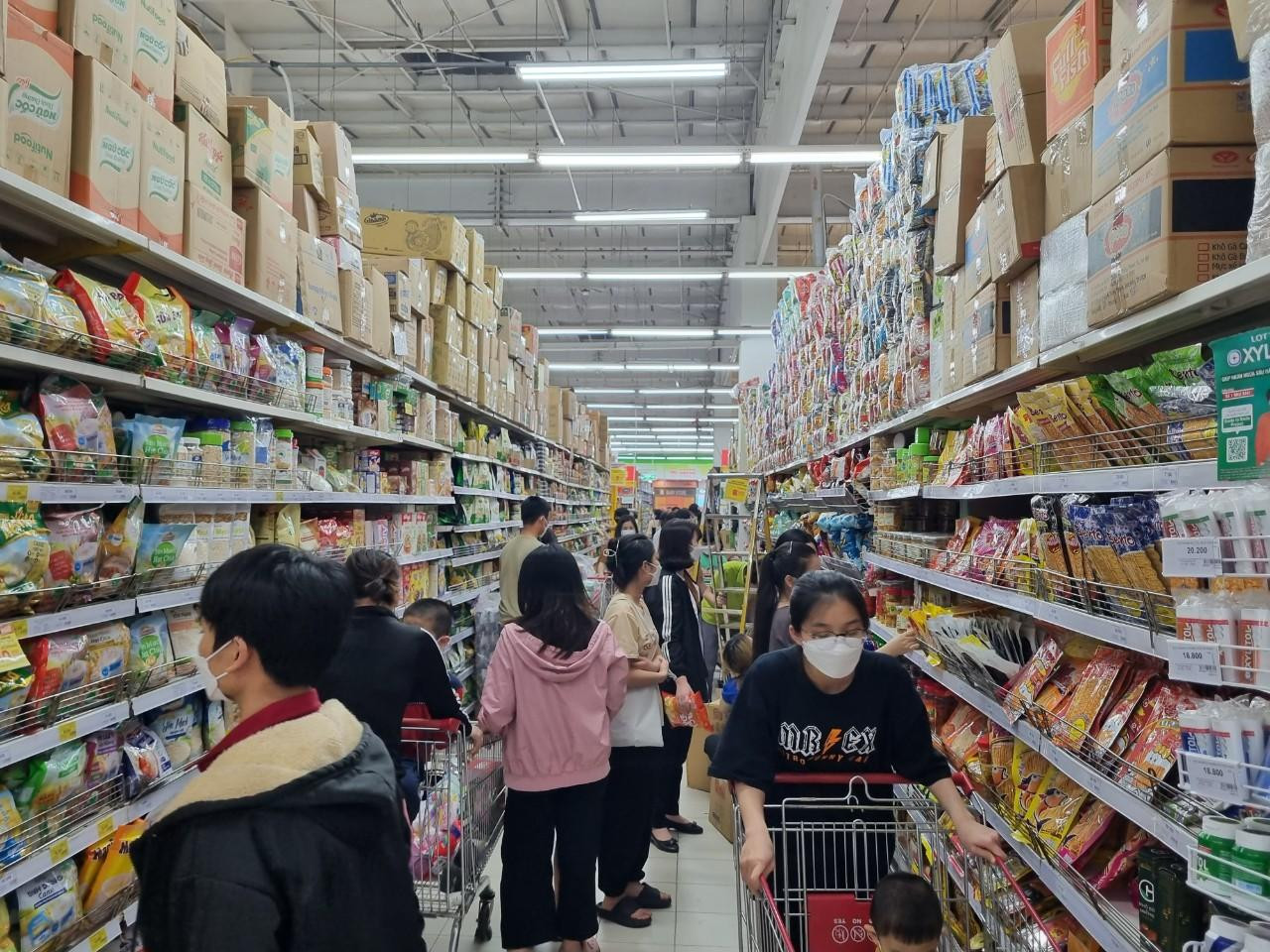 Tại Big C Long Biên, nhiều cửa hàng quần áo, mỹ phẩm… sáng 10/4, khách hàng phải xếp hàng dài chờ đến lượt thanh toán. Các sản phẩm từ quần áo, giày dép đến đồ ăn đều giảm giá vào ngày này. Tương tự, đại diện siêu thị Coopmart, Winmart... cho biết nhờ áp dụng chương trình giảm giá đến 50% cho nhiều mặt hàng, đặc biệt sản phẩm gia dụng, tiêu dùng nên thu hút lượng lớn khách trong sáng 10/4, thậm chí sức mua đã tăng từ ngày trước đó, đặc biệt đối với nhóm hàng thực phẩm tươi sống, hàng thiết yếu. Tuy vậy, nhờ chuẩn bị trước nguồn cung đa dạng nên không có tình trạng thiếu hụt sản phẩm. Trong ảnh: Người dân chen nhau mua sắm tại Big C. So với chợ truyền thống, nhiều mặt hàng tại đây đang giảm mạnh. Ảnh: Ngọc Mai.