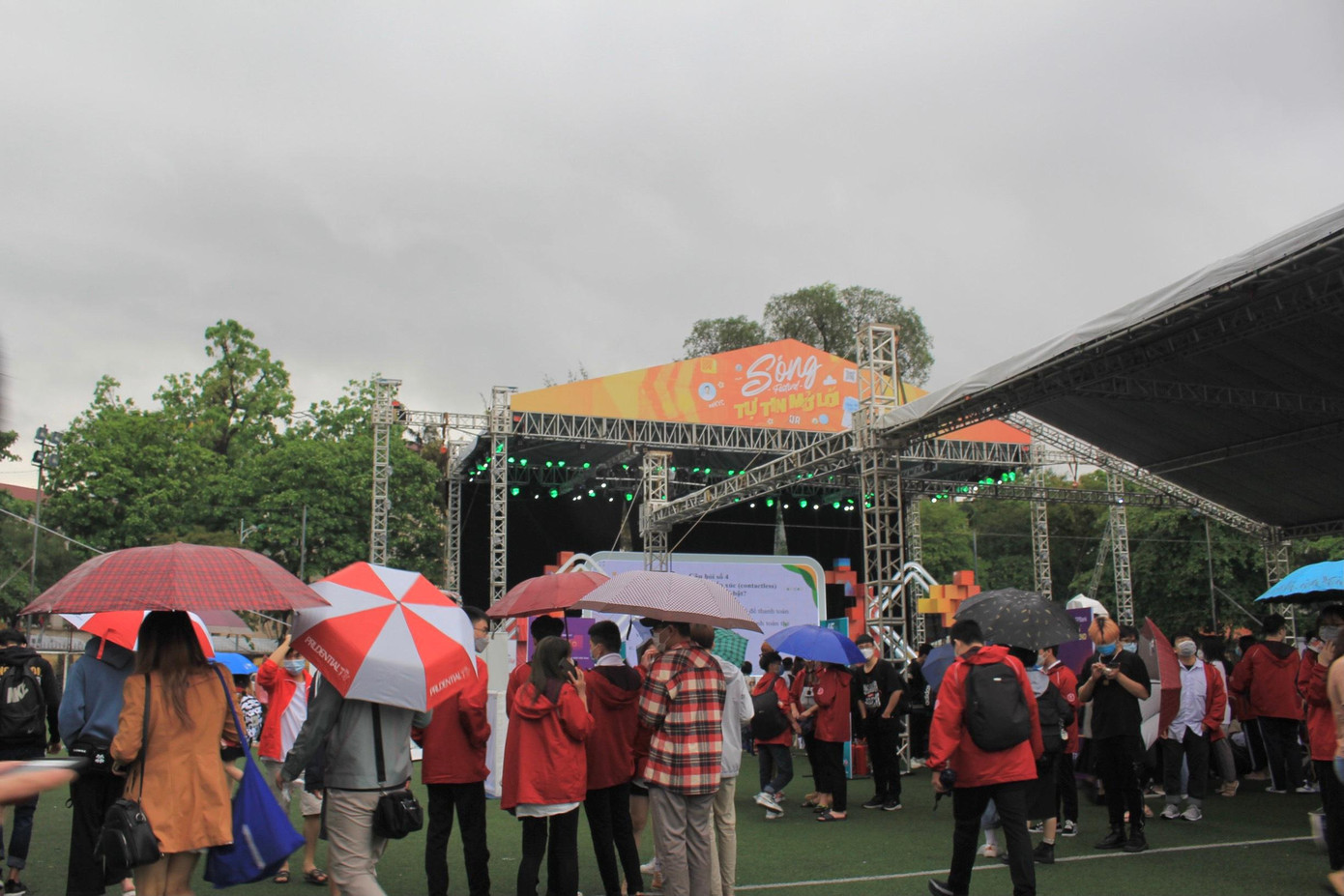 Xung quanh sân khấu chính, các bạn trẻ háo hứng chờ đón các tiết mục dưới mưa.