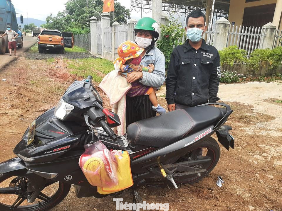 Vợ chồng anh A Su cùng con gái 18 tháng tuổi đèo nhau bằng xe máy từ Bình Dương về Kon Tum. Ảnh: Đình Văn