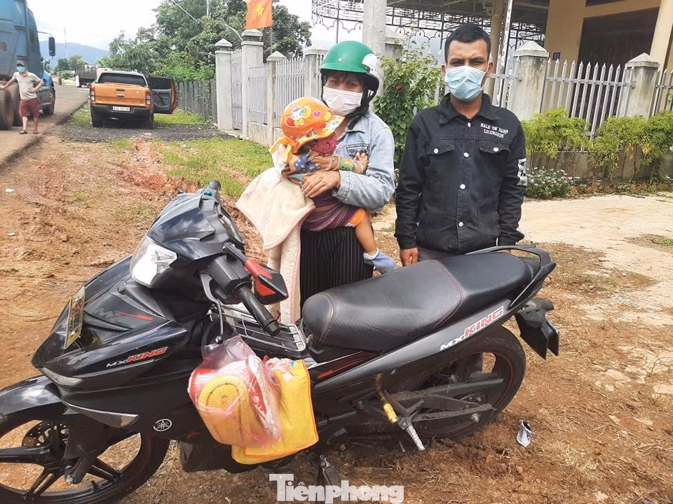 Vợ chồng anh A Su cùng con gái 18 tháng tuổi đèo nhau bằng xe máy từ Bình Dương về Kon Tum. Ảnh: Đình Văn