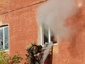 Một lính cứu hỏa Nga bước ra từ cửa sổ khu nhà xưởng bị cháy. Ảnh: Itar-tass Một lính cứu hỏa Nga bước ra từ cửa sổ khu nhà xưởng bị cháy